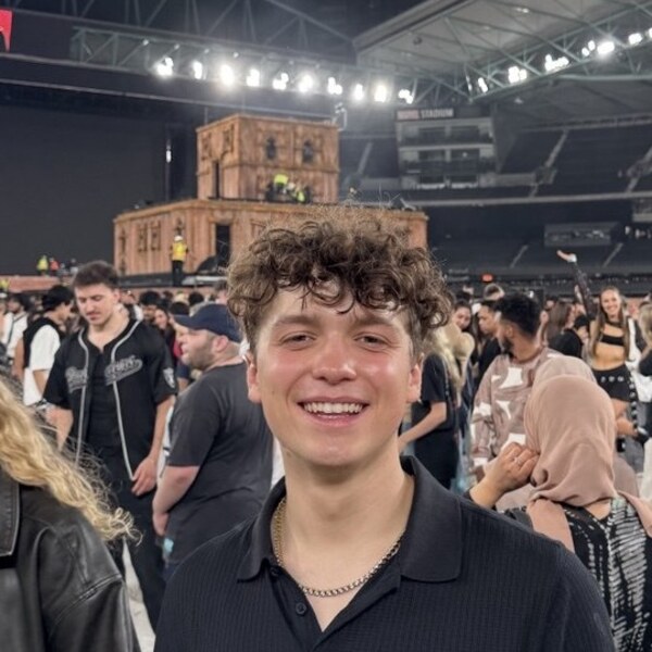 Kaleb Cole smiling in a crowded concert arena